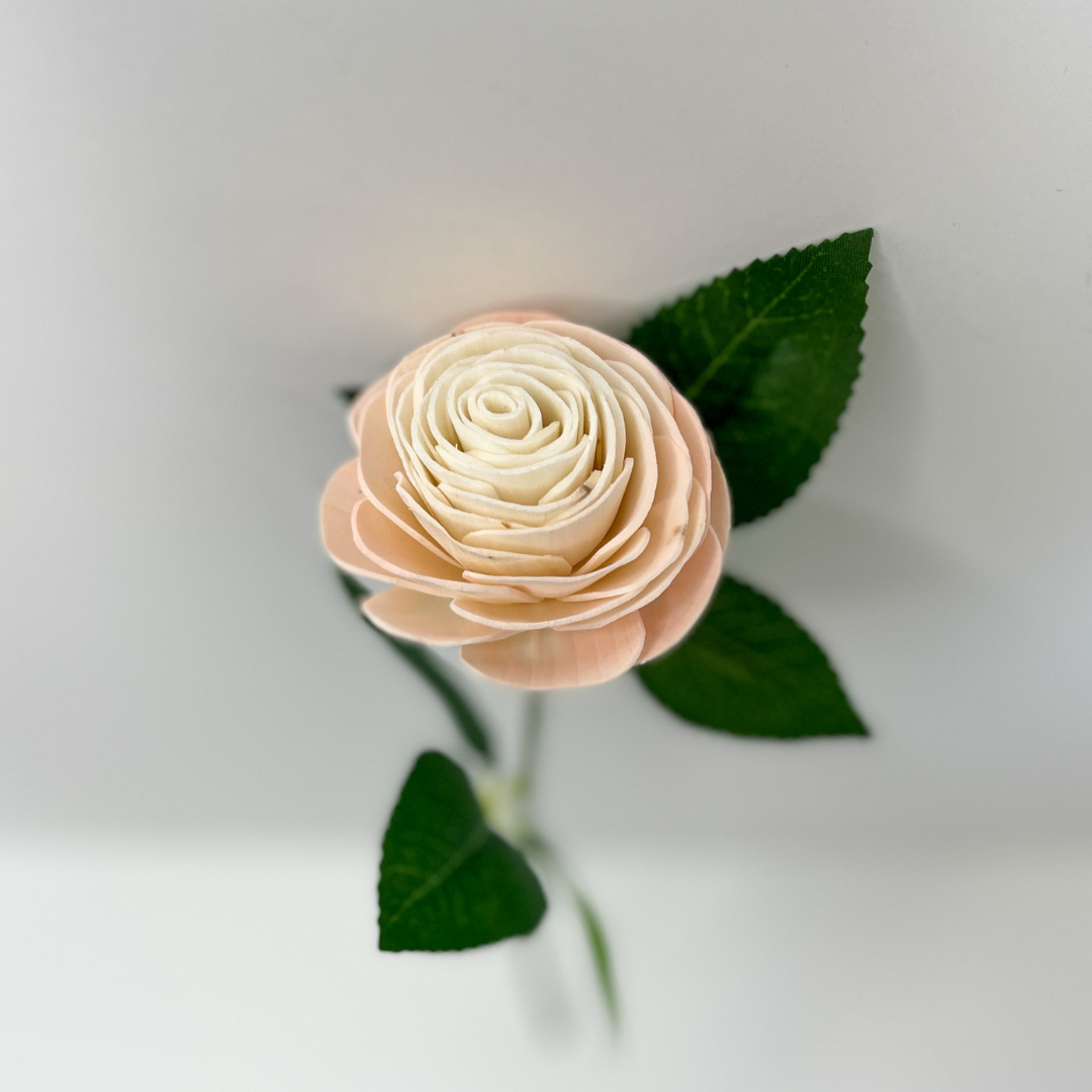 Single stem wooden rose with green leaves.