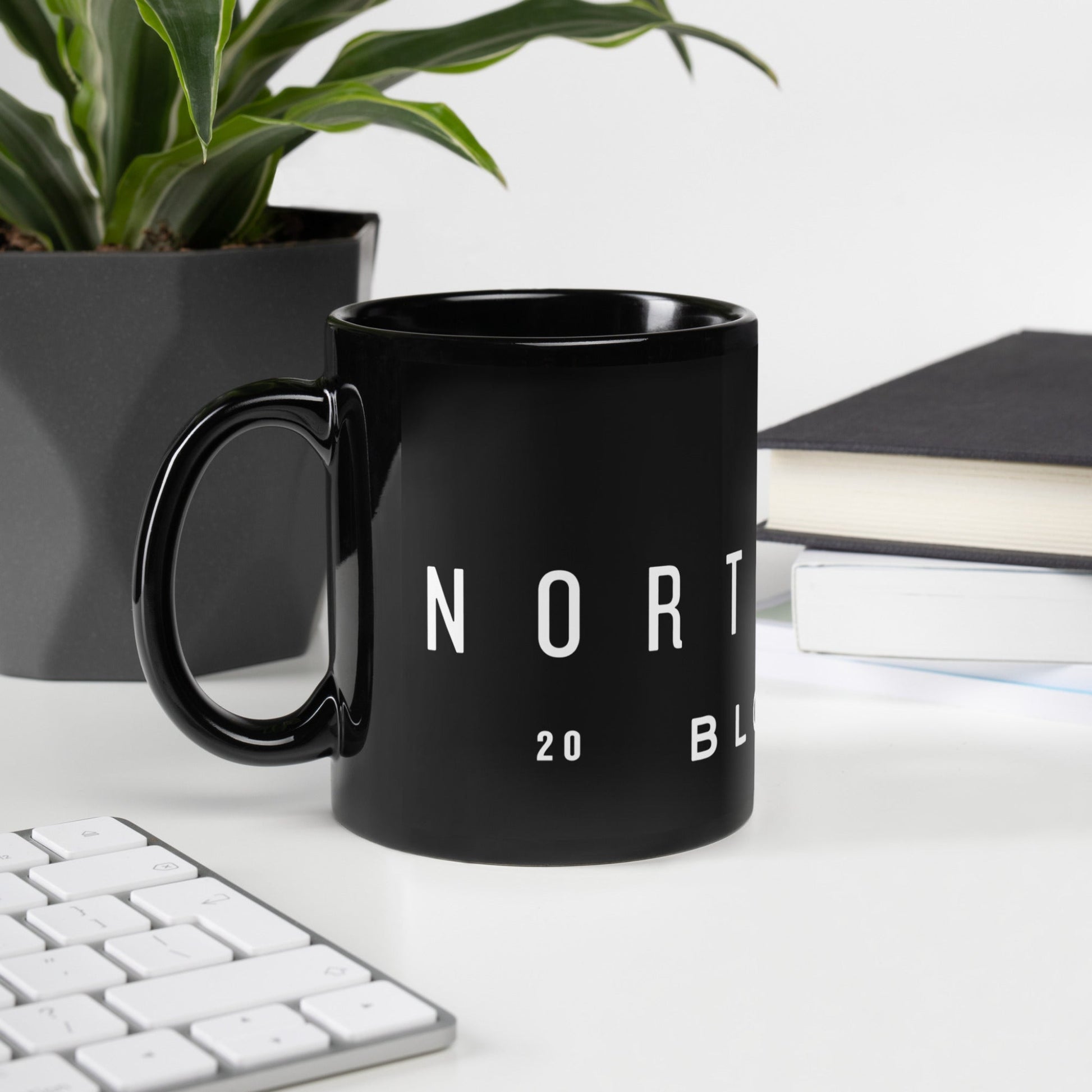 Glossy black mug with "North Wood Blooms" written in glossy white print.