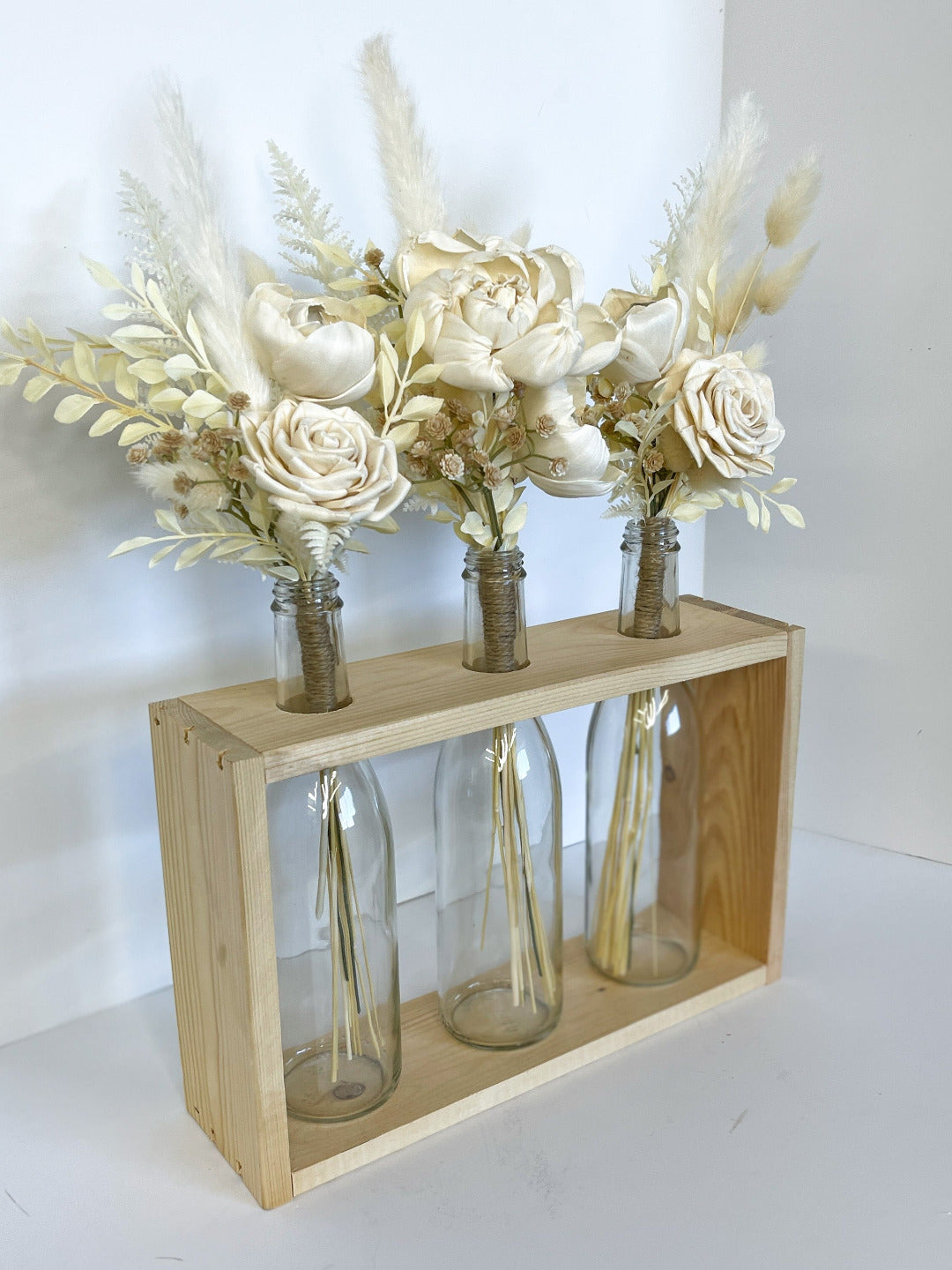 Boho bottle centerpiece with three clear vases and ivory handcrafted floral arrangement. 