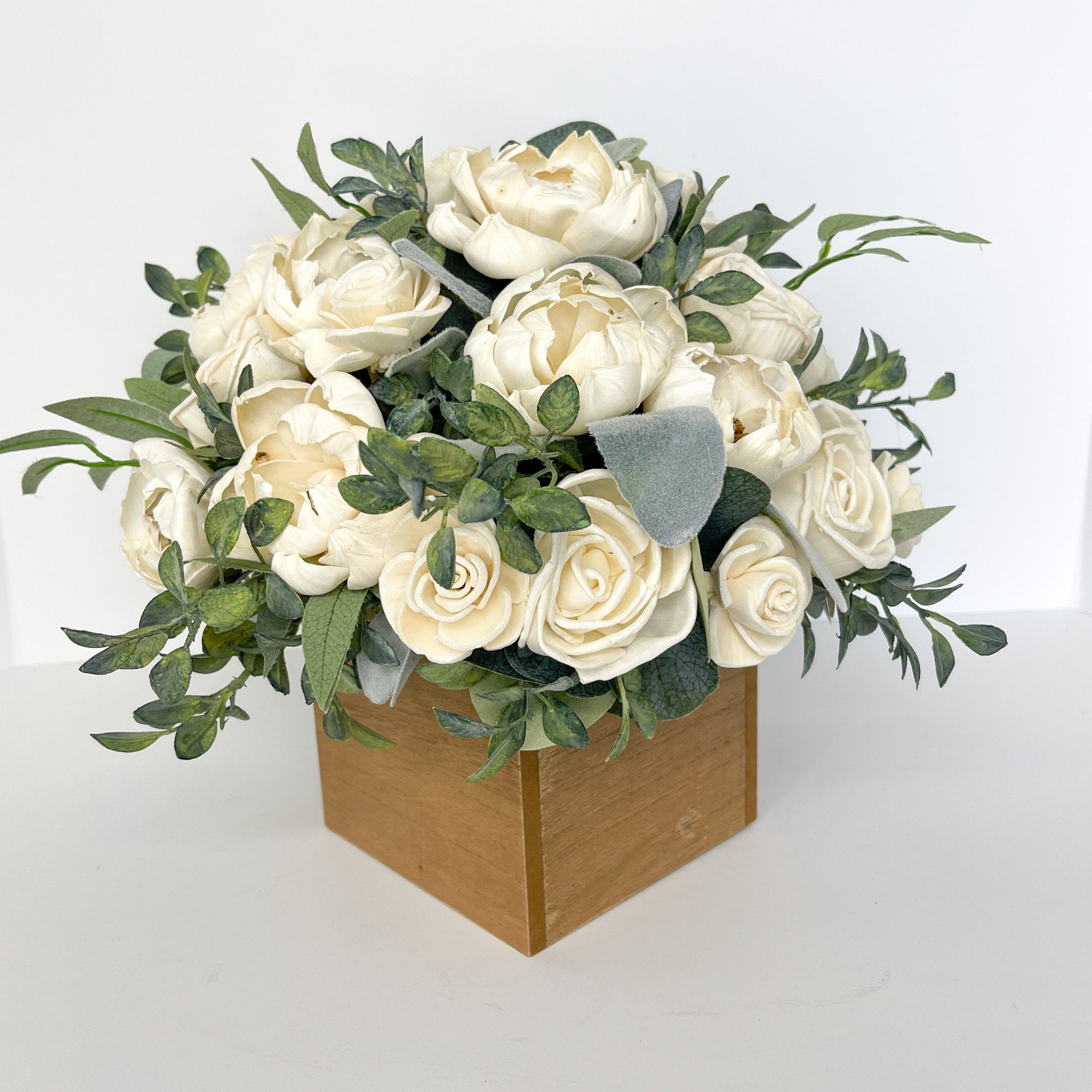 Ivory floral bouquet and wooden square center piece for decoration. 