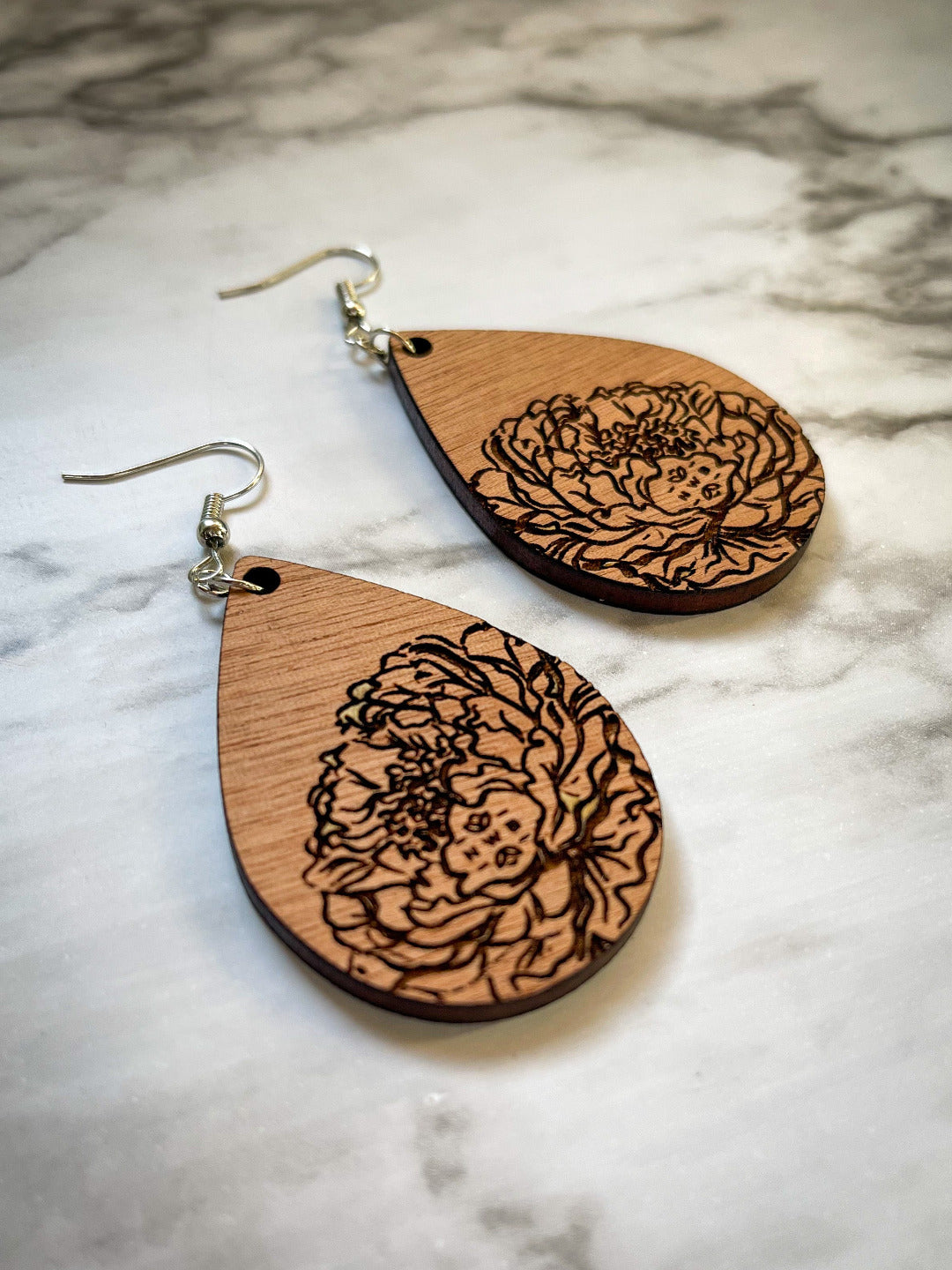 Wooded teardrop earrings with engraved floral design.